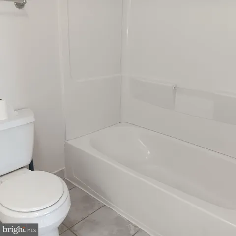 a white toilet sitting next to a bath tub