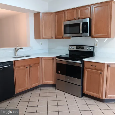a kitchen with granite countertop white cabinets stainless steel appliances and a sink