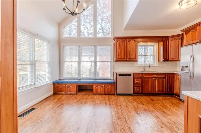 a living room with stainless steel appliances granite countertop a stove a sink and a large window