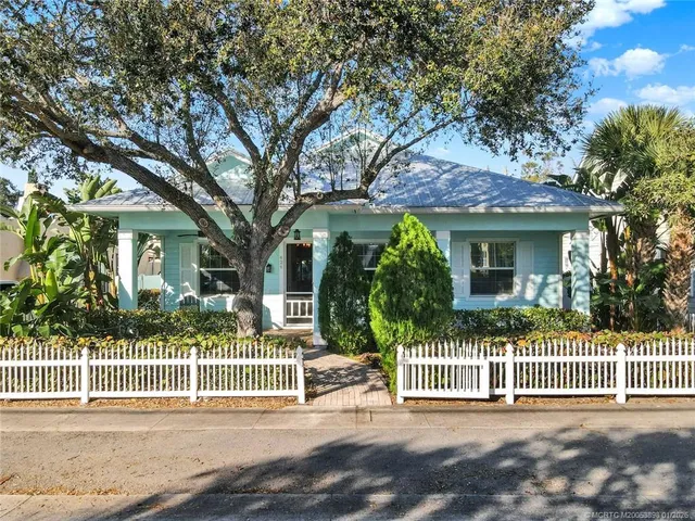 a front view of a house with a garden and plants