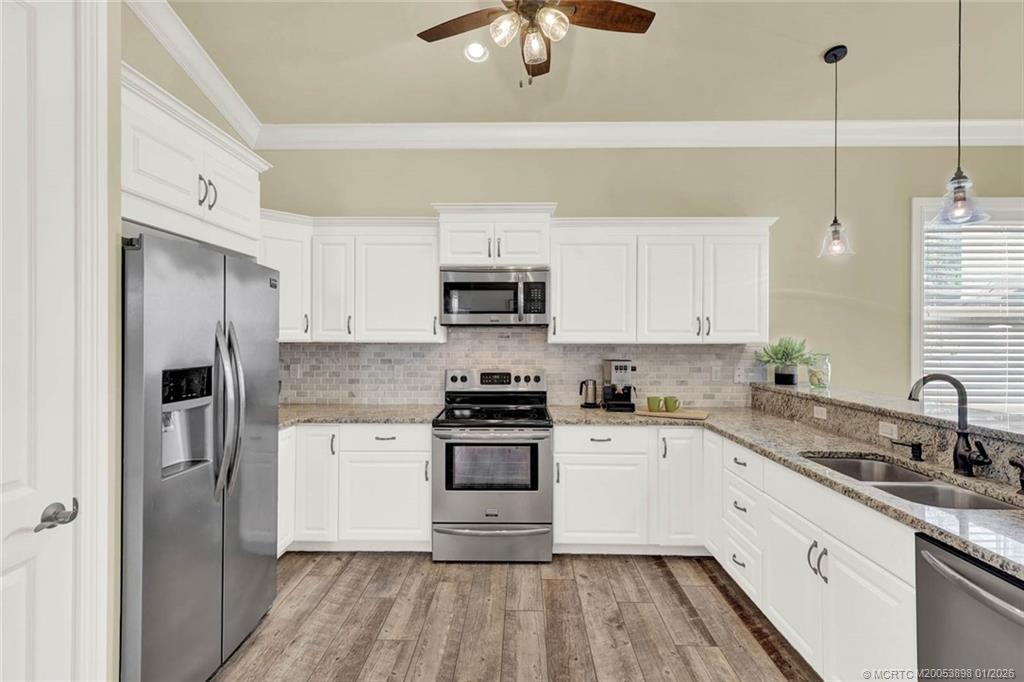 424 Southwest Camden Avenue Stuart, FL 34994 - Photo 11 of 58 a kitchen with a sink stainless steel appliances and white cabinets