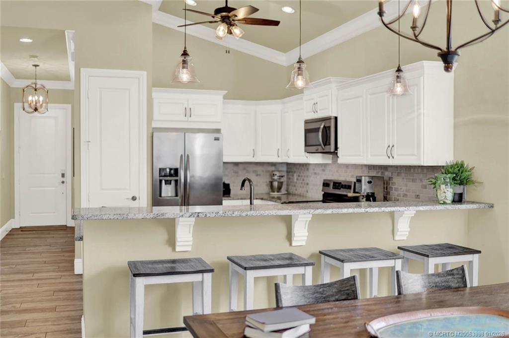 424 Southwest Camden Avenue Stuart, FL 34994 - Photo 16 of 58 a kitchen with stainless steel appliances kitchen island granite countertop a sink and cabinets