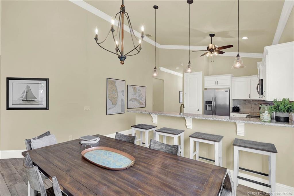 424 Southwest Camden Avenue Stuart, FL 34994 - Photo 18 of 58 a view of a dining room with furniture a chandelier and wooden floor