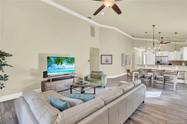 a living room with furniture a flat screen tv and a large window
