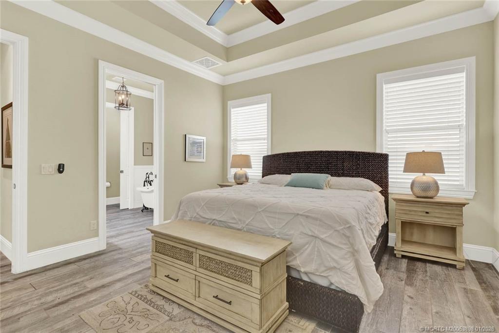 424 Southwest Camden Avenue Stuart, FL 34994 - Photo 28 of 58 a spacious bedroom with a bed and a chandelier