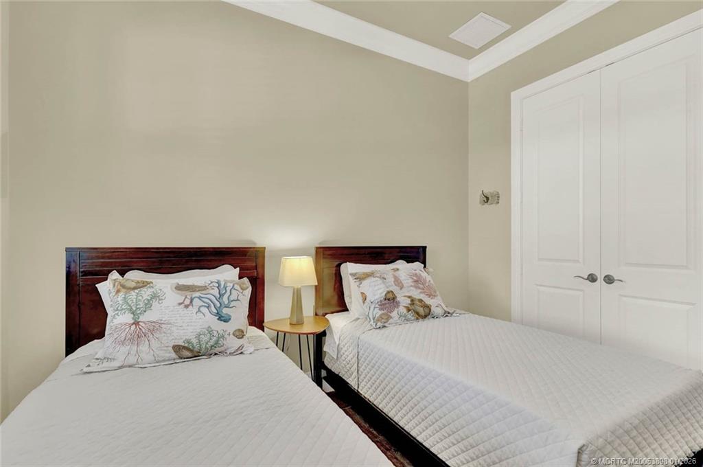 424 Southwest Camden Avenue Stuart, FL 34994 - Photo 38 of 58 a large bed sitting in a bedroom next to a cabinet