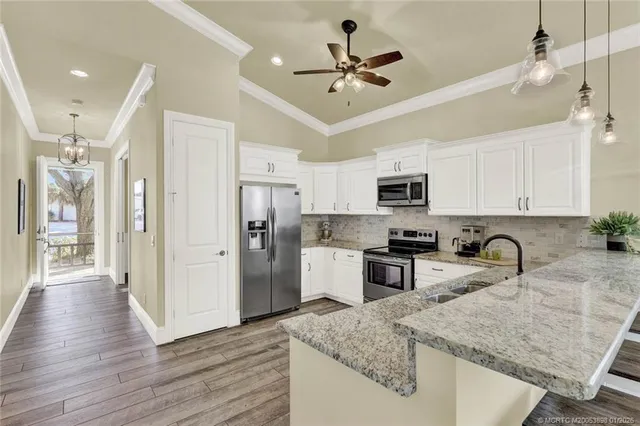 a kitchen with a sink stainless steel appliances and white cabinets