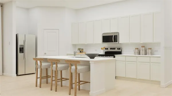 a kitchen with stainless steel appliances a stove a sink white cabinets and a refrigerator