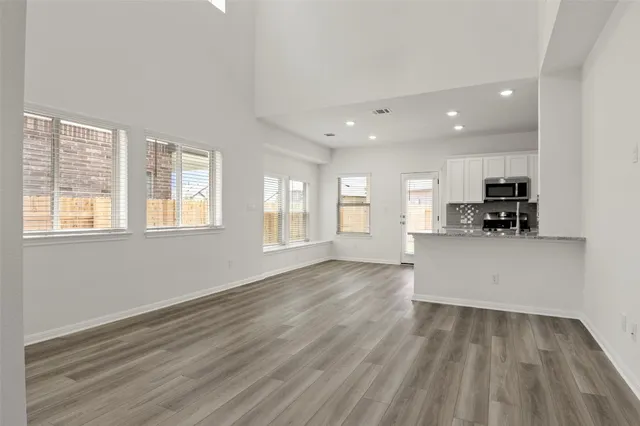 a view of a hallway with wooden floor and stairs