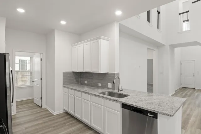 a kitchen with granite countertop a sink and cabinets