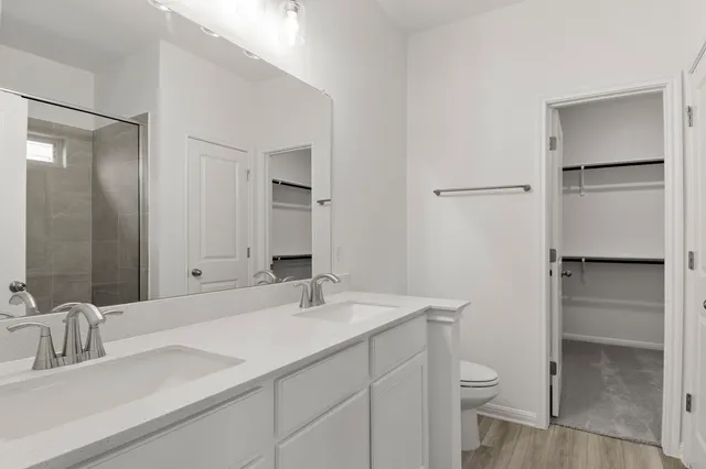 a bathroom with a sink toilet double vanity and tub