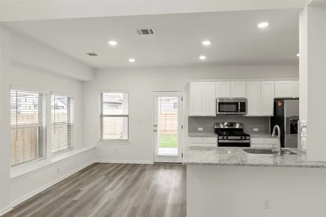 a kitchen with stainless steel appliances granite countertop a sink stove and refrigerator