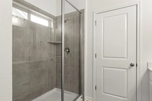 a view of an empty room with a chandelier fan
