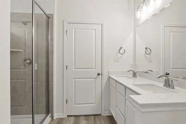 a bathroom with a sink toilet double vanity and tub