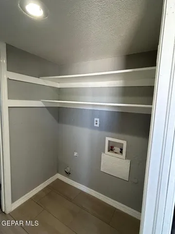 a view of an empty room and window and chandelier fan