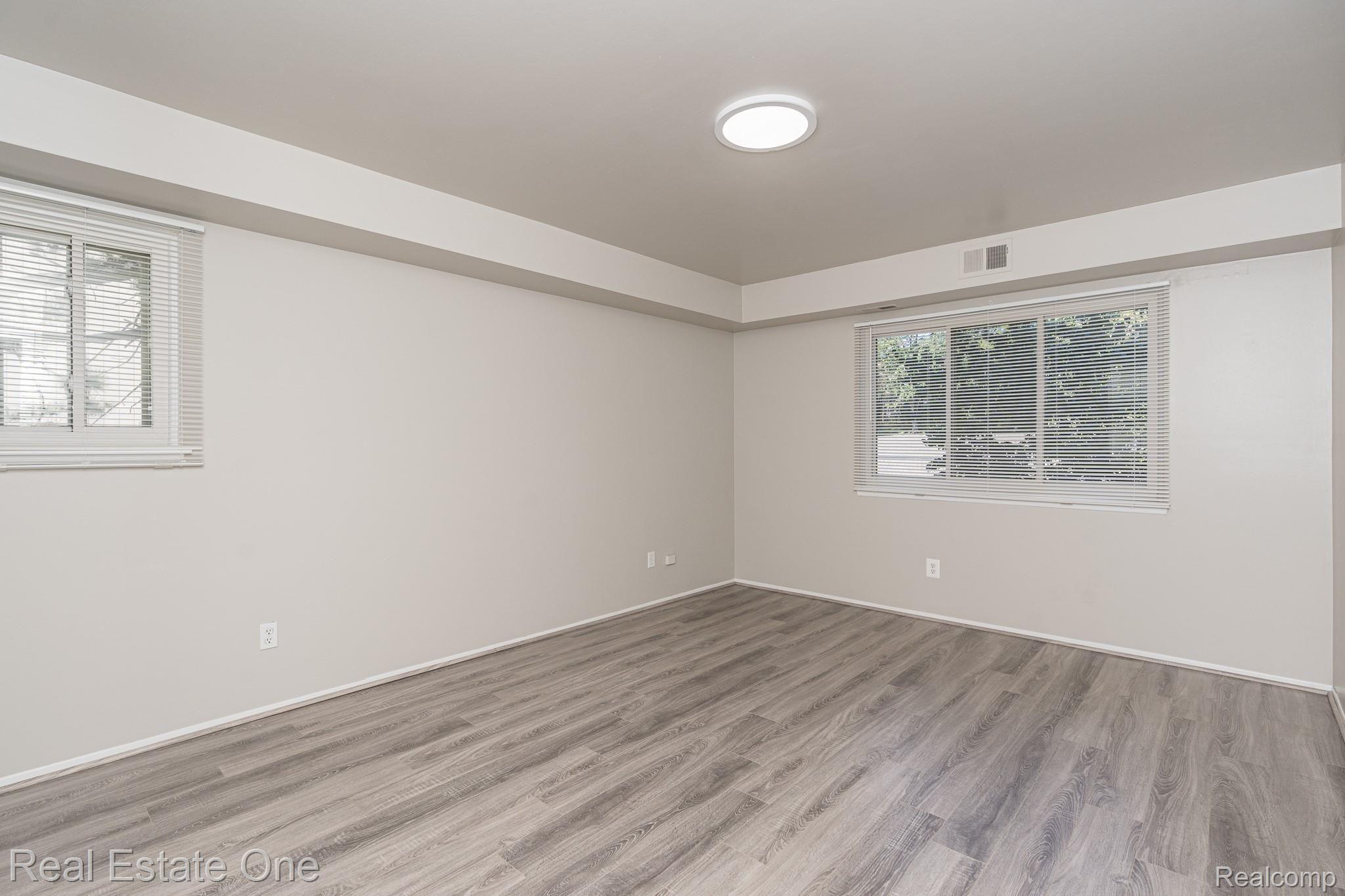 1677 Riverside Drive, Unit 16 Rochester, MI 48309 - Photo 15 of 31 MAIN BEDROOM HAS WALK-IN CLOSET AND WINDOWS ON 2 SIDES - ATTRACTIVE & DURABLE WOOD-LOOK FLOOR - 1677 Riverside MLS-W029.jpg