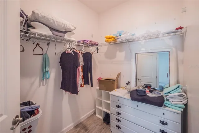 a view of walk in closet with clothes and shoes