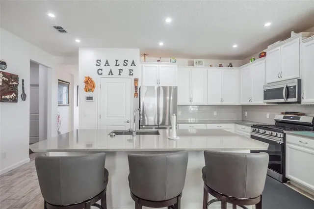 a kitchen with kitchen island a white cabinets and chairs