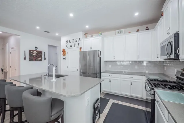 a kitchen with stainless steel appliances granite countertop a sink stove and refrigerator