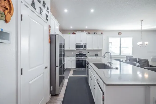 a kitchen with kitchen island granite countertop a sink a counter top space stainless steel appliances and cabinets