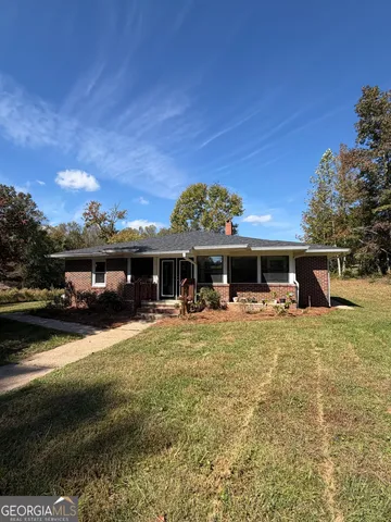 a front view of house with yard barbeque and outdoor seating