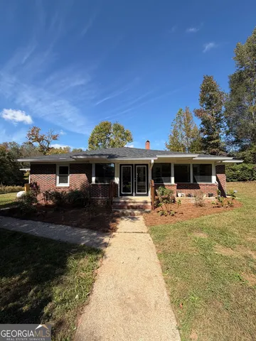 a front view of a house with swimming pool and furniture
