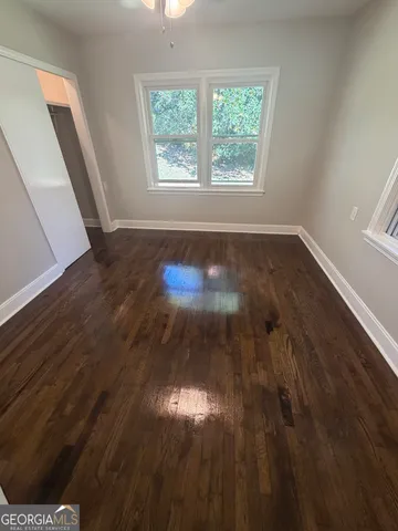 a view of empty room with wooden floor