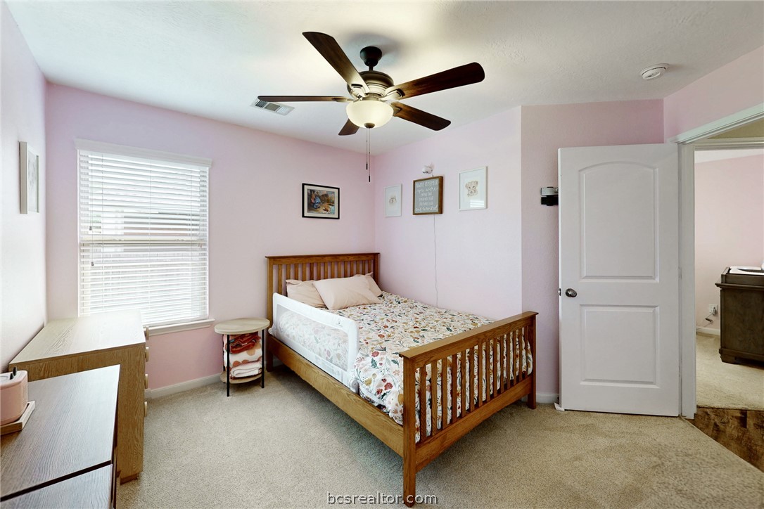2071 Positano Loop Bryan, TX 77808 - Photo 23 of 31 a bedroom with a bed and a ceiling fan