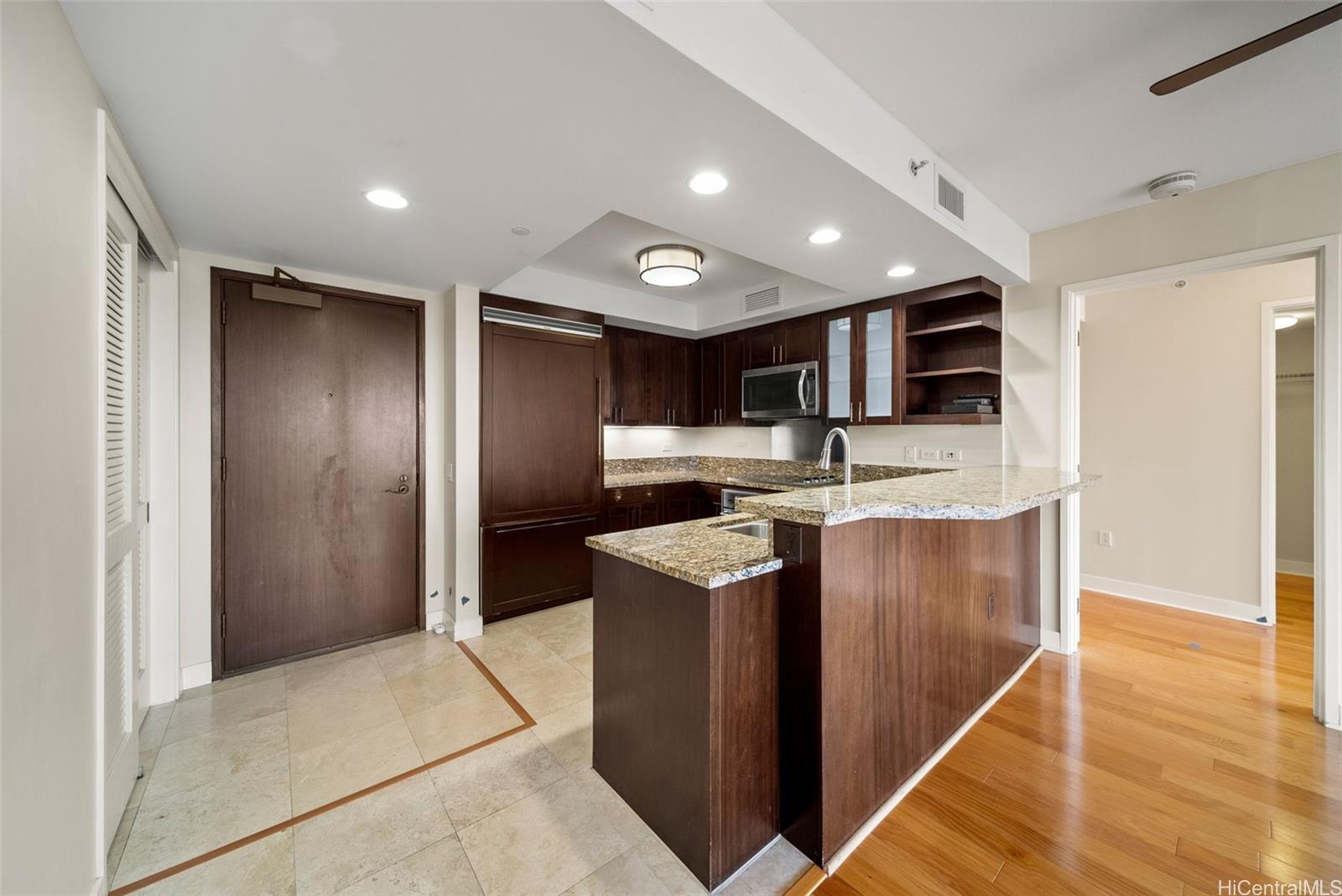 1551 Ala Wai Boulevard, Unit 504 Honolulu, HI 96815 - Photo 10 of 25 a kitchen with stainless steel appliances kitchen island granite countertop a refrigerator and a stove top oven