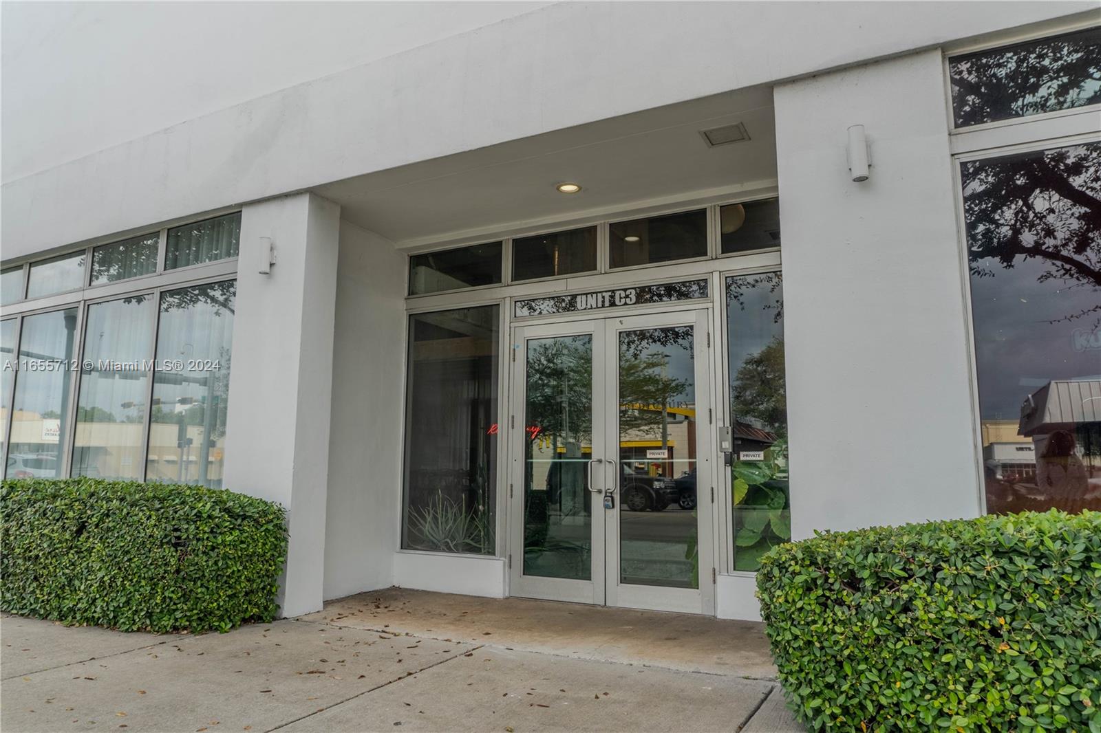 front view of a house with a large window and potted plants