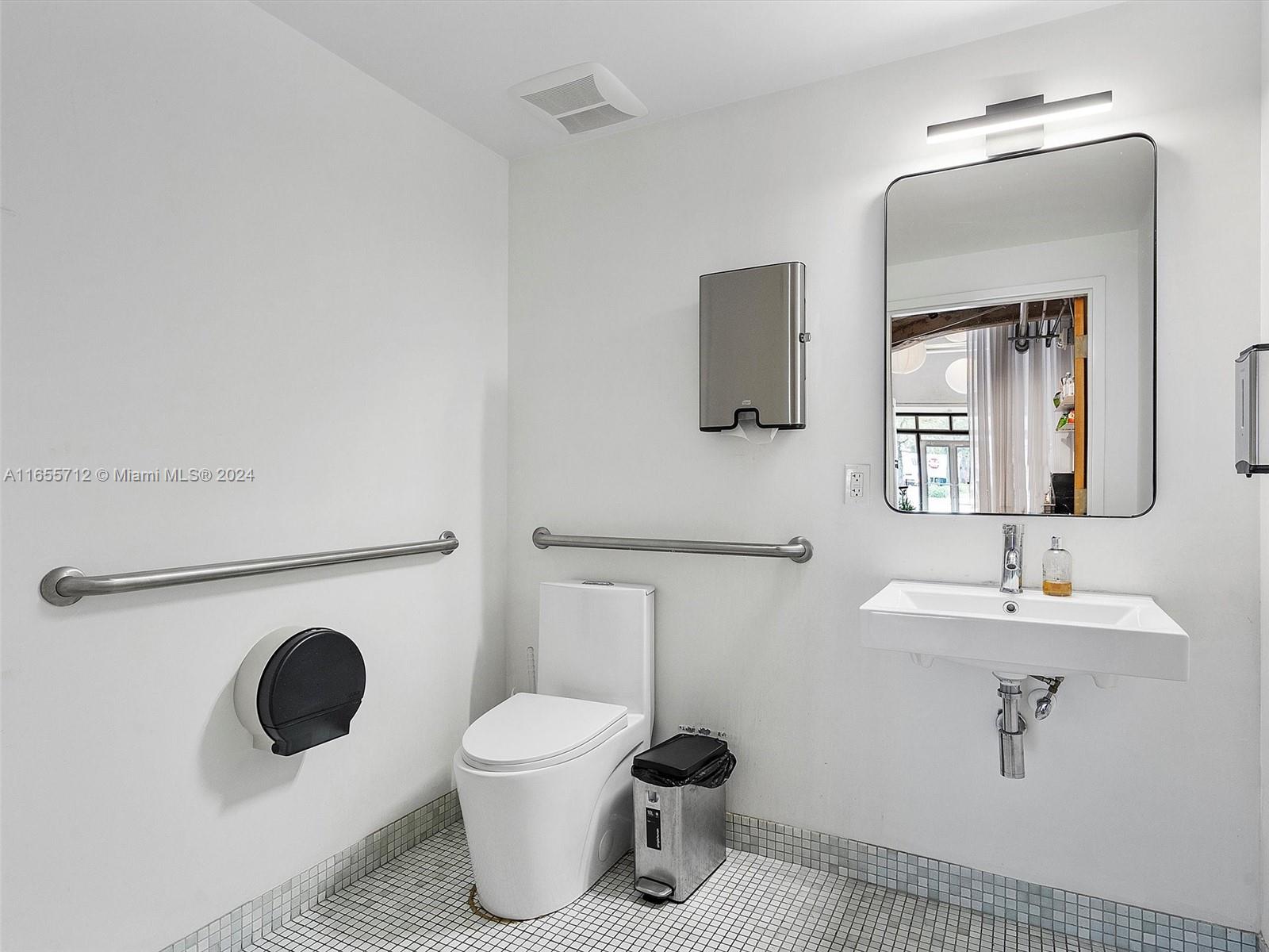 8101 Biscayne Boulevard, Unit C3 Miami, FL 33138 - Photo 19 of 25 a bathroom with a toilet a sink and mirror