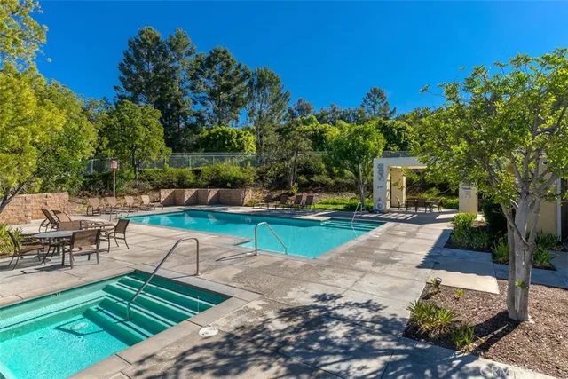 a view of a patio with table and chairs potted plants and a palm tree