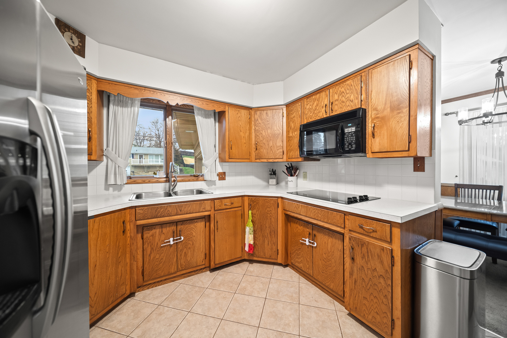 3138 12th Avenue Moline, IL 61265 - Photo 10 of 34 a kitchen with stainless steel appliances granite countertop a refrigerator a sink dishwasher a stove top oven a washer and dryer with wooden cabinets