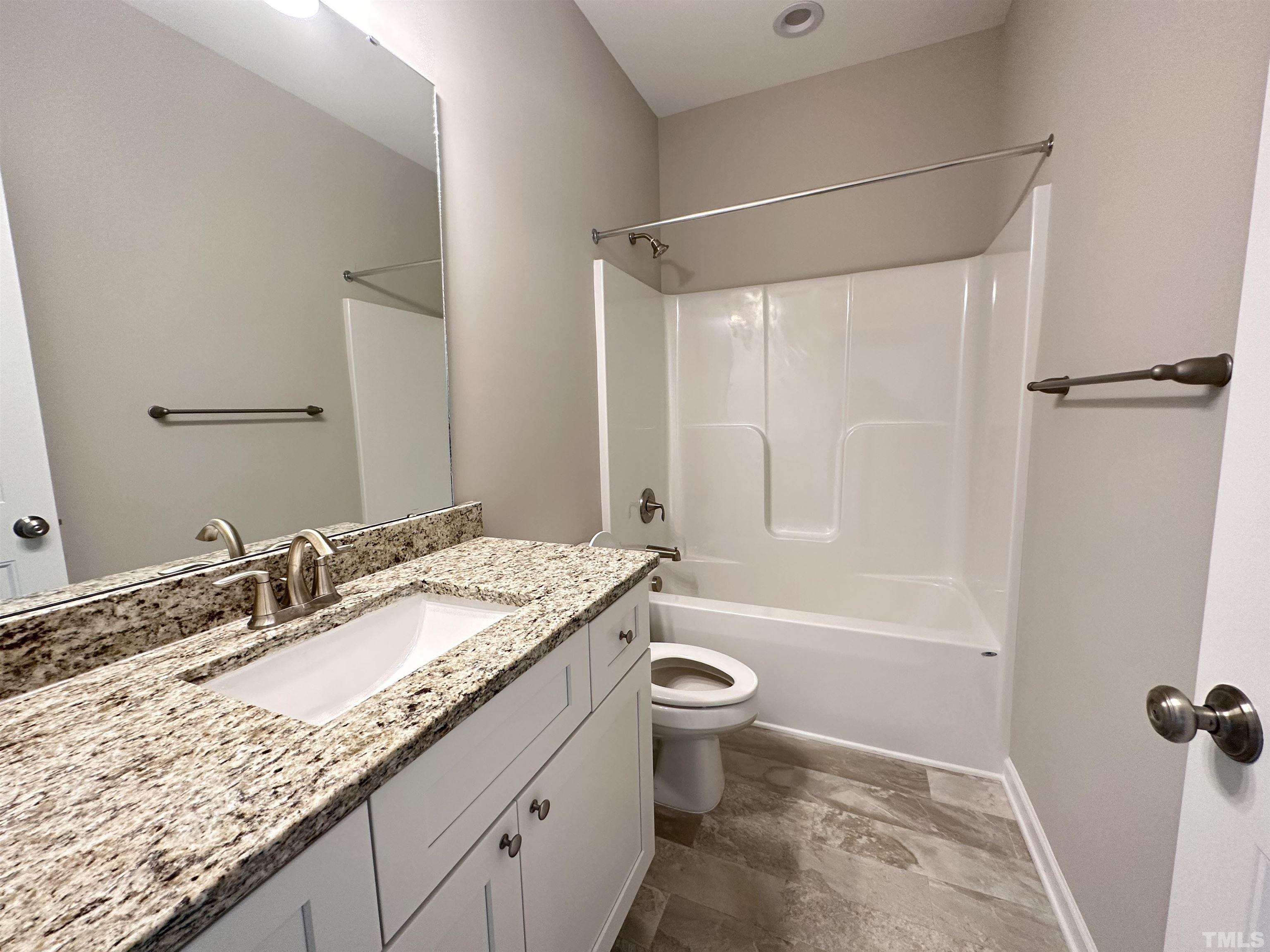7519 Springfield School Road Lucama, NC 27851 - Photo 7 of 8 a bathroom with a granite countertop sink toilet and shower