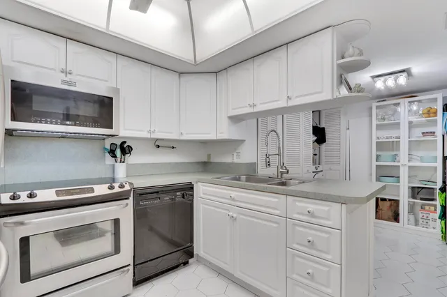 a kitchen with stainless steel appliances granite countertop a sink a stove and cabinets