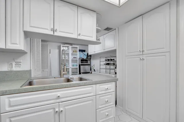 a kitchen with white cabinets and a sink