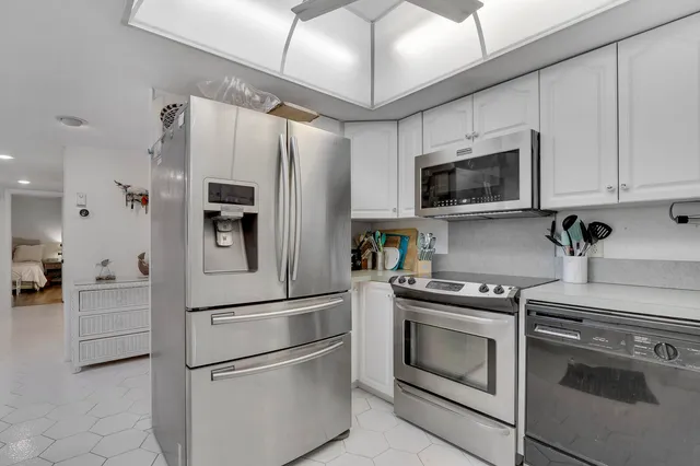 a kitchen with stainless steel appliances white cabinets and a stove