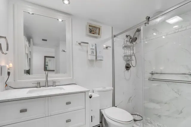 a bathroom with a sink toilet vanity and shower