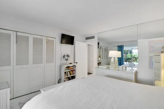 a bedroom with a bed a table and a large mirror