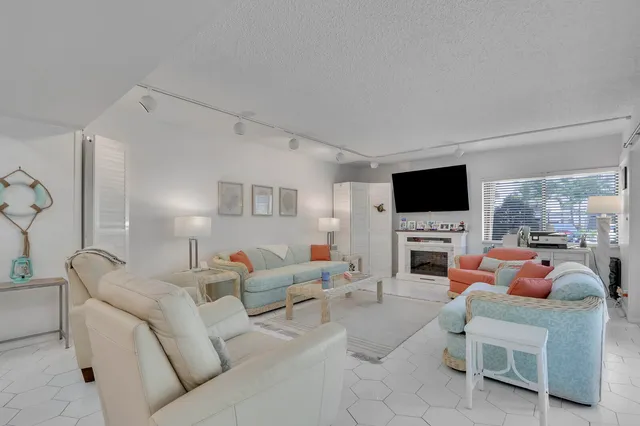 a living room with furniture a flat screen tv and a fireplace