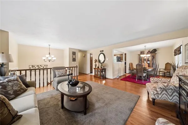 a living room with furniture a rug and a mirror