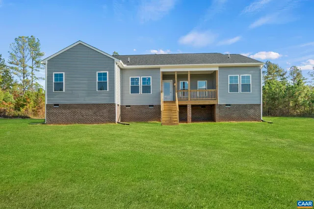 an aerial view of residential houses with outdoor space and lake view