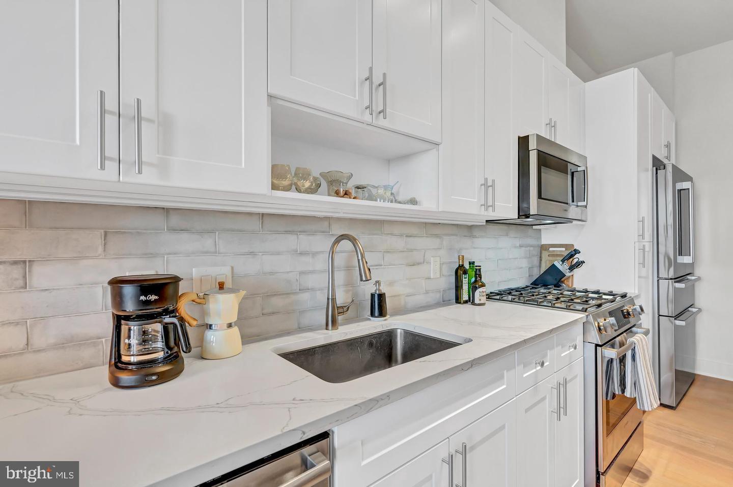 6803 Cameron Drive Northwest, Unit 514 Washington, DC 20012 - Photo 14 of 50 a kitchen with stainless steel appliances a sink a stove and cabinets