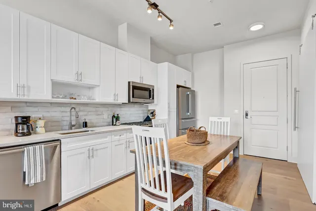 a kitchen with white cabinets and sink