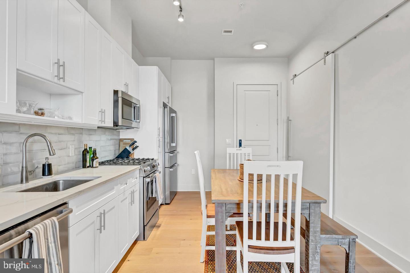 6803 Cameron Drive Northwest, Unit 514 Washington, DC 20012 - Photo 16 of 50 a kitchen with white cabinets and sink