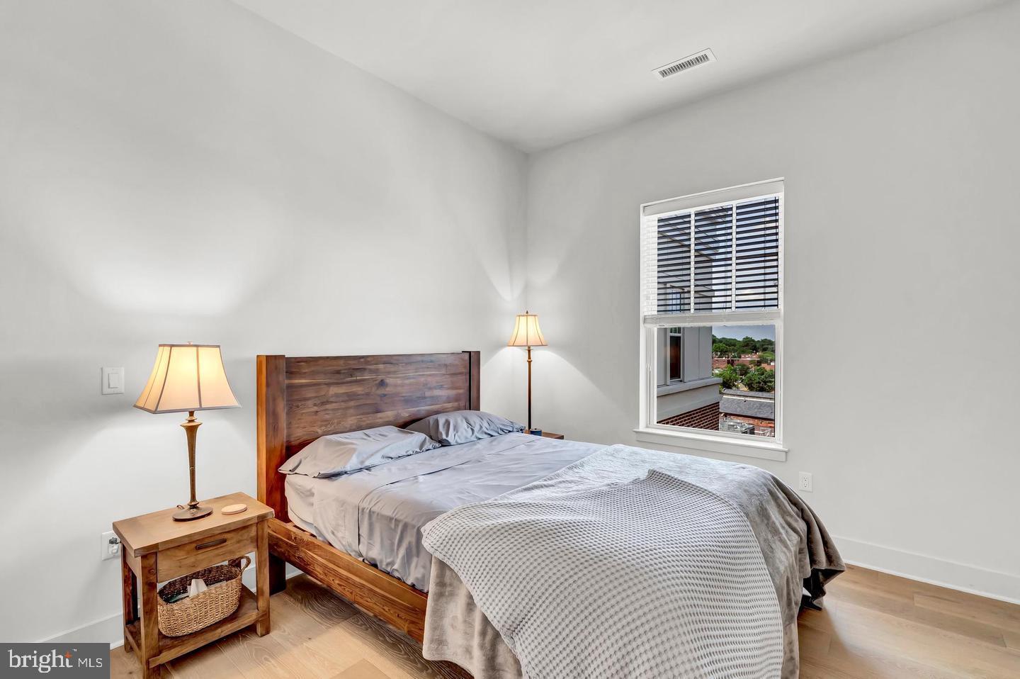 6803 Cameron Drive Northwest, Unit 514 Washington, DC 20012 - Photo 25 of 50 a bedroom with a bed and a night stand