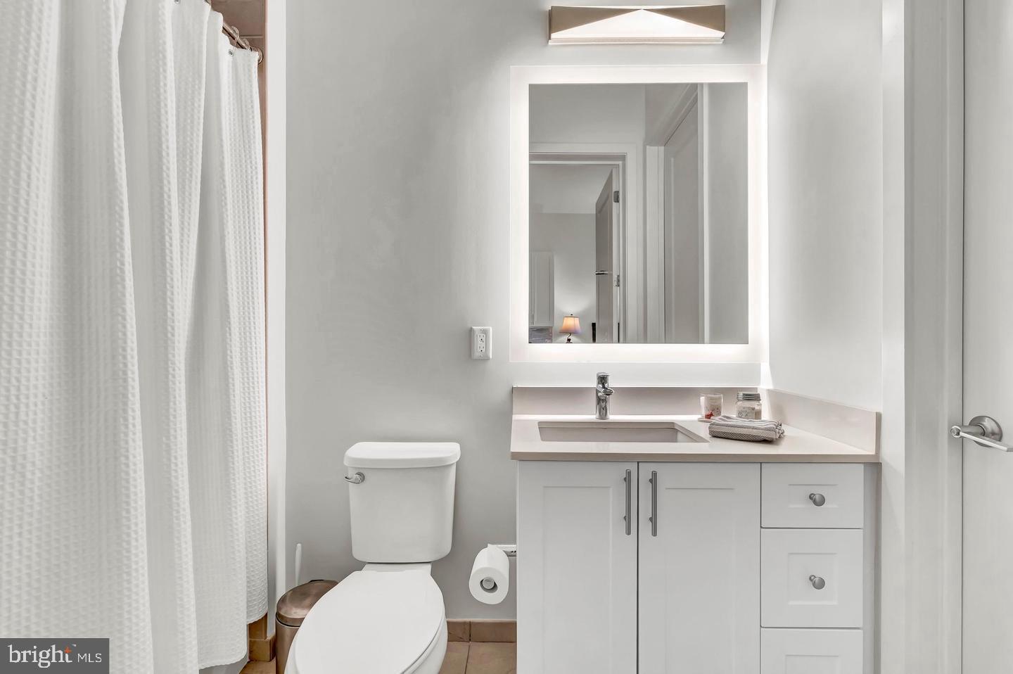 6803 Cameron Drive Northwest, Unit 514 Washington, DC 20012 - Photo 28 of 50 a bathroom with a toilet sink and mirror