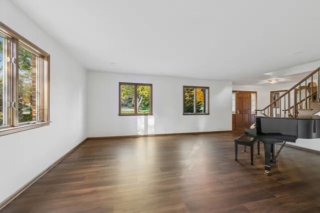a view of an empty room with window and wooden floor