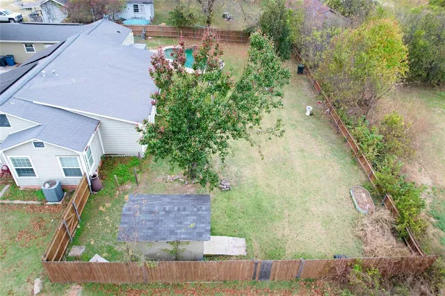 an aerial view of a house with a yard and greenery