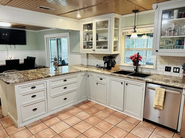 a kitchen with granite countertop white cabinets and white appliances